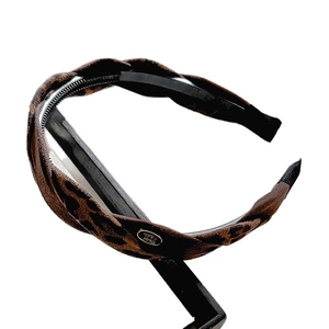 French vintage leopard print knotted headband with golden badge on a display stand