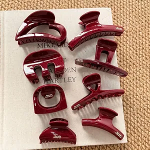 Set of 8 deep red sparkling shark hair clips with golden logo on white fabric book