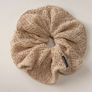 Détail du chouchou en maille beige avec tissage ajouré et étiquette faite main
