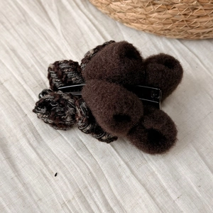Vue détaillée de la pince à cheveux banane en fourrure peluche marron foncé et tweed