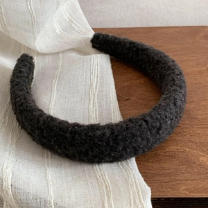 Detailed close-up of dark grey thick faux fur headband with fluffy lamb wool texture