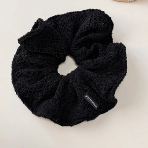 Détail d'un chouchou en dentelle crochetée noire avec texture de tissu fait main