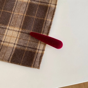 Close-up of a vintage dark red velvet hair clip with a stylish duckbill metal clasp