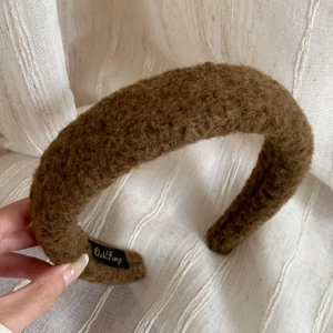 Detailed macro view showing the textured brown plush faux shearling fabric of the headband