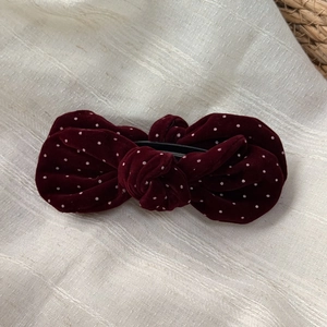 Detailed view of the velvet wine red bow hair clip with white polka dots and back clamp
