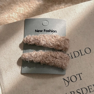 Gros plan de barrettes à cheveux élégantes en peluche kaki sur une carte de support
