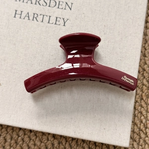 Close-up of a burgundy claw clip with fine glitter and gold Barrette La France logo
