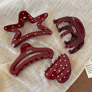 Set of four glossy wine red hair claws in various shapes for women's hairstyling