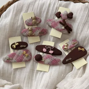 Close-up of pink and brown houndstooth hair clips with cute bear and bow details