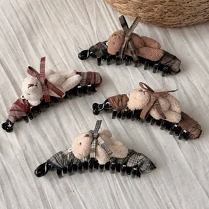 Detail of four teddy bear hair clips with plaid bows and soft plush material