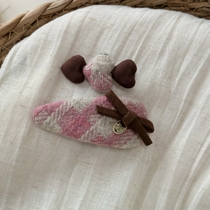 Vue détaillée de barrettes à cheveux en tweed rose et gris avec nœuds élégants