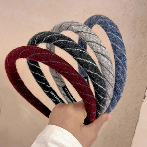 Set of four knitted striped headbands in burgundy, grey and blue colors for women