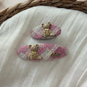Détail de deux pinces à cheveux en tissu avec oursons marrons et étiquette en métal fait main