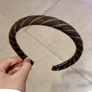 Detailed close-up of handmade wine red diagonal pattern headband with a textile texture