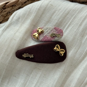 Détail de pinces à cheveux en pied-de-poule rose et marron café avec nœud doré et Always