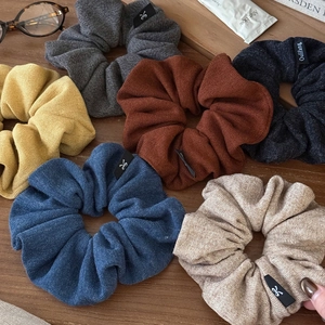 Lot de six grands chouchous en tricot de différentes couleurs sur surface en bois