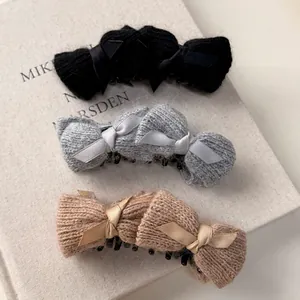 Three-piece knitted banana clips set with satin bows in black, grey, and camel tones