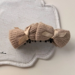 Detailed macro view of khaki knit fabric and satin ribbon bow on the hair clip