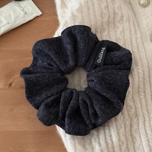 Vue détaillée du chouchou en peluche grise avec étiquette sur texture douillette