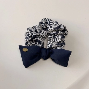 Détail du chouchou bleu marine avec broderie florale et boucle en métal doré