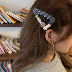 Gray felt hair clip with rhinestones and bunny decoration worn by female model