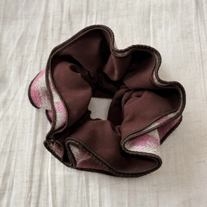 Détail du chouchou à carreaux rose et marron avec texture de tissu et coutures