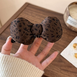 Leopard print bow banana clip with padded fabric texture for elegant hair styling