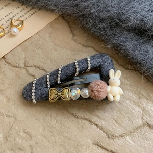 Detailed close-up of a premium grey felt hair clip with rhinestone chains and a cute rabbit
