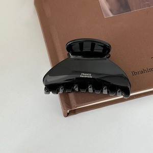 Detailed macro view of black acetate hair claw with France Handmade lettering and sturdy teeth