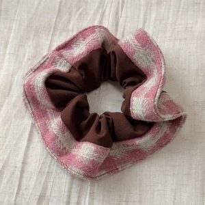 Vue détaillée du chouchou en tweed à carreaux roses avec couche interne en tissu brun