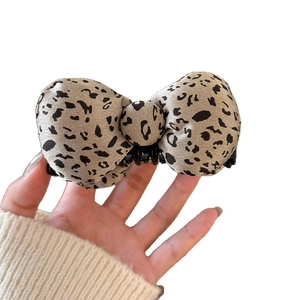 Leopard print bow banana clip made of soft fabric with a central button and black base