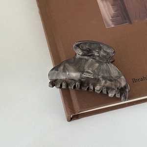 Close-up of elegant grey marble acetate hair claw clip with France Handmade lettering