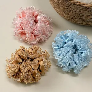 Three sequined satin mesh hair scrunchies in pink, blue, and champagne gold for women