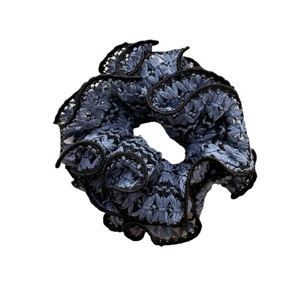 Blue lace scrunchie with woven floral patterns and black wavy embroidery edges