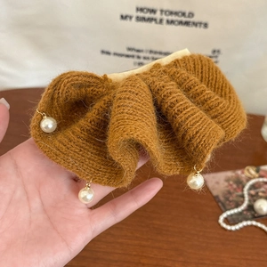 Détail d'une pince à cheveux en maille caramel avec volants et perles suspendues