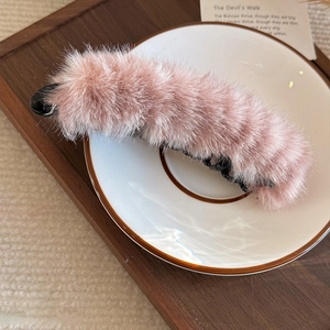 Détail de la pince banane en peluche rose montrant la fourrure et les dents internes