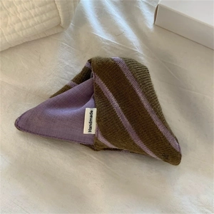 Detail der grün-violett gestreiften Strick-Haarklammer mit weißem Handmade-Label