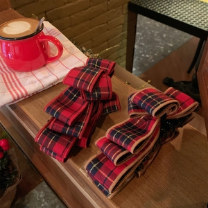 Red plaid bow banana clips for women, elegant checkered hair accessories in a winter cafe setting
