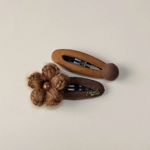 Detailed view of coffee-colored fabric hair clips with crochet flower and bead accent