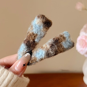 Gros plan de pinces à cheveux en peluche tissée bleue et marron montrant la maille