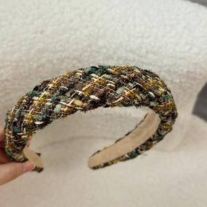 Close-up of retro tweed padded headband featuring intricate multi-color woven texture