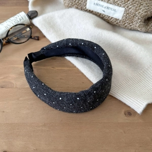 Close-up of thick charcoal grey wool blend headband with white polka dots and texture