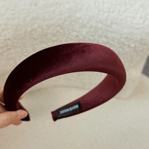 Detail of burgundy velvet headband showing soft texture and handmade interior label