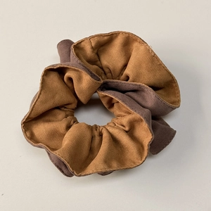 Detailed macro view of dual-tone yellow and brown fabric texture on a scrunchie
