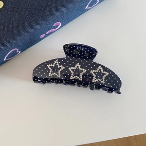 Detail view of navy blue polka dot hair claw clip with sparkling rhinestone stars decor