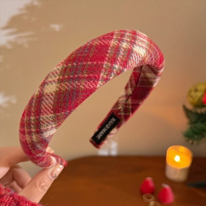 Detail of red plaid velvet headband showing the HAND MADE woven label and fabric texture