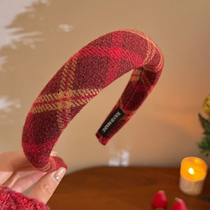 Detail of red plaid thick sponge headband with a black Hand Made woven label inside