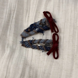 Detail view of retro plaid hair clips with burgundy velvet bows and frayed edges set