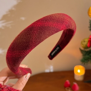 Detail of handmade red plaid wool headband showing soft texture and premium inner label