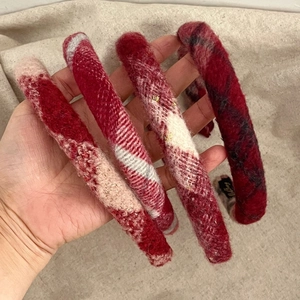 Detailed view of plush red plaid headbands with soft wool-like texture for Christmas
